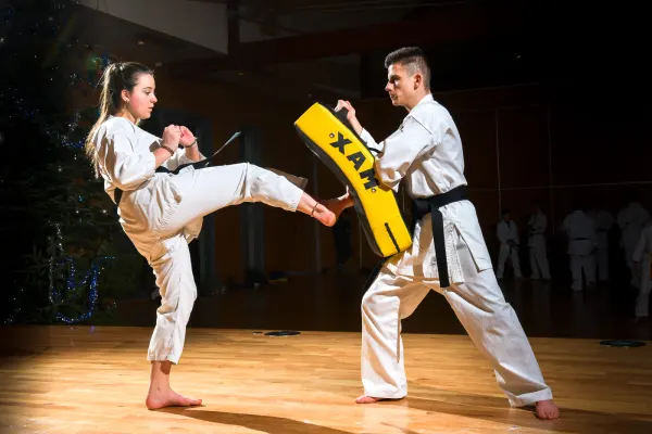 Entraînement de karaté à Sancé à l’École des 3 Énergies, pratiquante réalisant un coup de pied sur une cible.